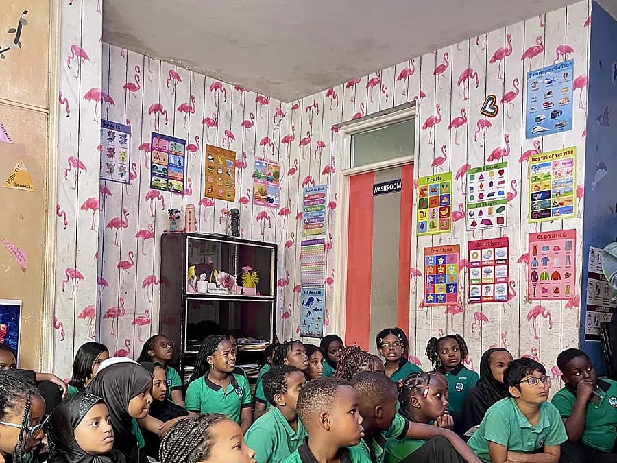 Enfants et adultes écoutent une lecture en classe
